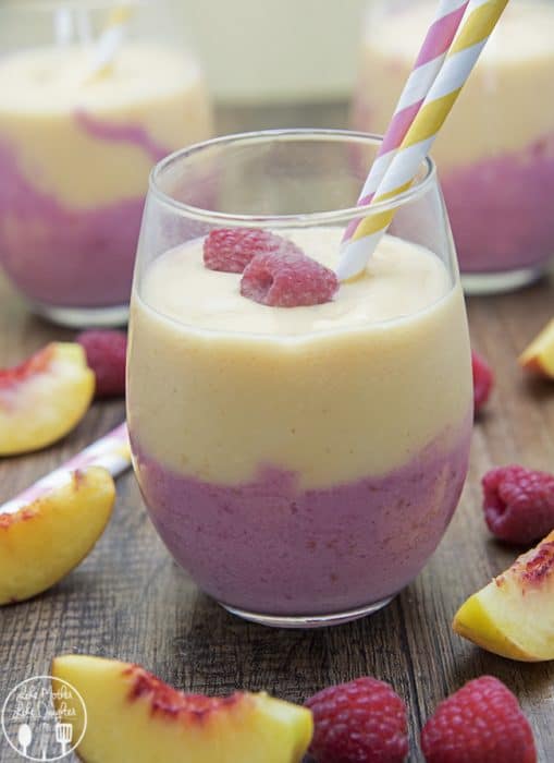 Raspberry Peach Smoothie in a glass with two straws