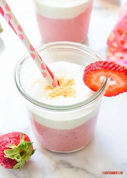 Overhead view of Roasted Strawberry Cheesecake Smoothie in a glass with two straws